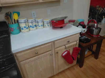Floral canister set, red stand mixer, red pot and kitchen utensils on counter