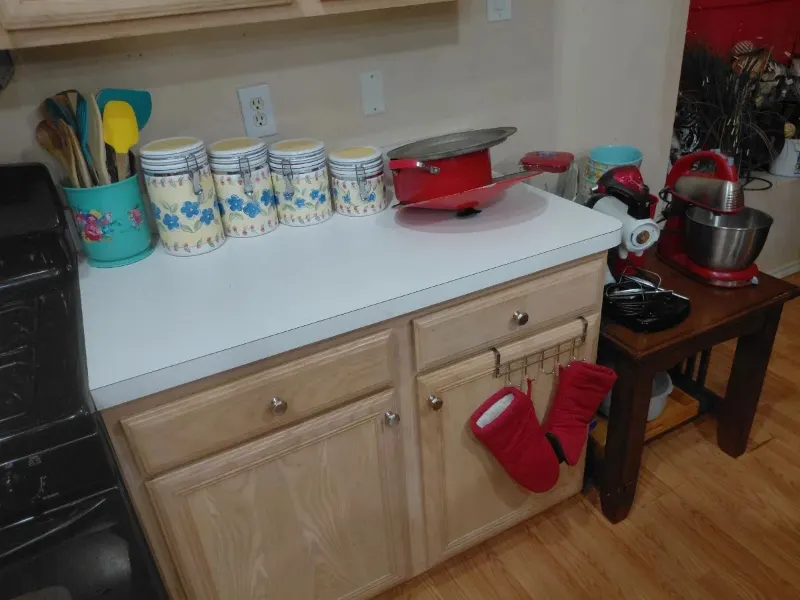 Floral canister set, red stand mixer, red pot and kitchen utensils on counter