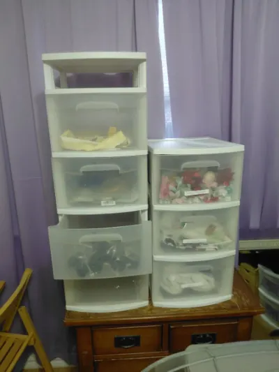 Two white plastic storage drawer carts with craft supplies and fabric
