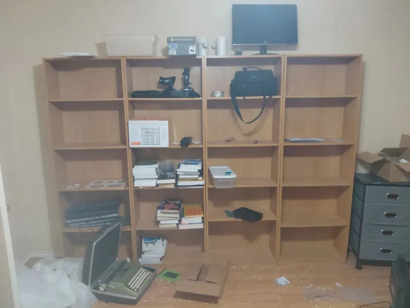 Four oak-finish bookcases, vintage portable typewriter, LG monitor and books